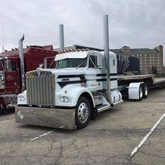 two semi trucks parked in a parking lot