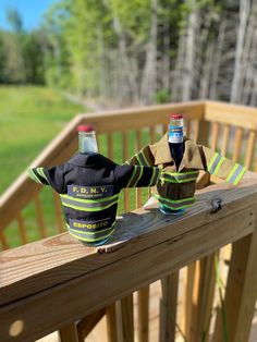 two fireman hats sitting on top of a wooden deck next to bottles of beer