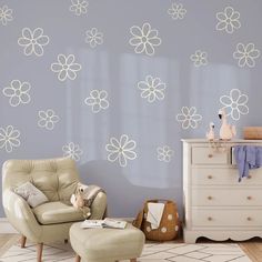 a living room with a chair, ottoman and flower wall decals