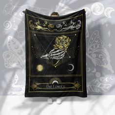 a black and gold cloth with a rose on it hanging from a hook in front of a wall