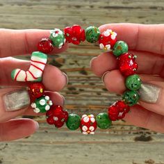 a person holding a bracelet made out of candy canes and christmas decorations on it