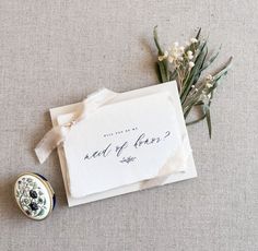 a close up of a piece of paper with writing on it next to some flowers