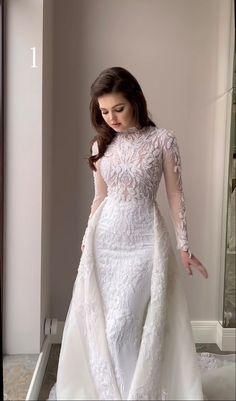 a woman in a white wedding dress is posing for the camera with her hands on her hips