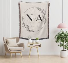 a chair and table in front of a white wall with a tapestry hanging on it