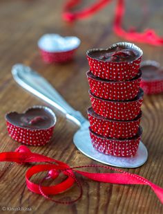 a stack of red and white polka dot cupcakes on top of a wooden table