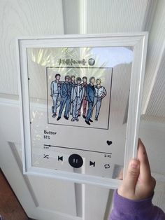 a person holding up a digital device with an image of men in suits on it