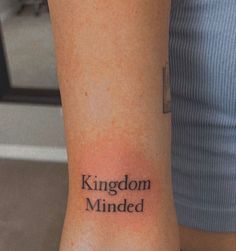 a person with a tattoo on their arm that reads kingdom minded and the word is written in black ink