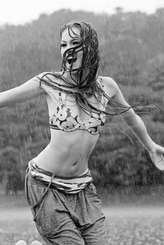 black and white photograph of a woman in the rain with her arms spread wide open