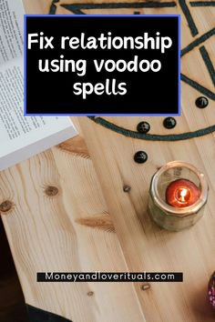 a candle sitting on top of a wooden table next to an open book with the title fix relationship using voodoo spells