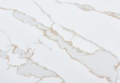 a white marble counter top with gold veining on the edges and an abstract design