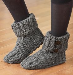 the legs of a woman wearing gray knitted boots