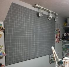 there is a gray tile wall in the kitchen with shelves on either side and an overhead fan above it