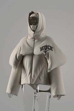 a mannequin wearing a white jacket with an embroidered logo on the hood and sleeves