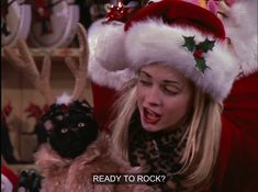 a woman wearing a santa claus hat and holding a stuffed animal in her hand with the caption ready to rock?