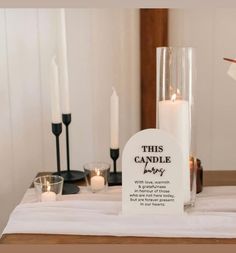 candles are placed on a table with a sign that says, this candle belongs