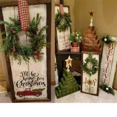 christmas decorations are displayed on the floor in front of a wall with wooden signs and wreaths