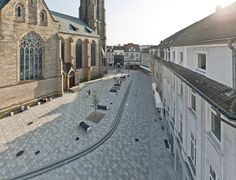 an aerial view of a street with buildings and a clock tower in the back ground