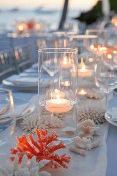 the table is set with candles and seashells