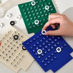 a person using a blue and green calculator to make numbers on the table