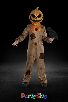 a person in a halloween costume holding a bird and wearing a jack o lantern mask