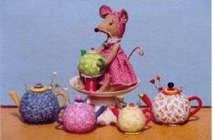 a mouse figurine sitting on top of a table next to teapots