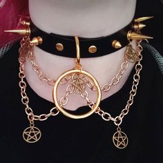 "\"Risen\" is the brass twin to \"Fallen\". \"Risen\" is a stunning statement piece, featuring a hanging 1.5 inch O-ring, 5 small pentacle charms, and 4 brass chains. It's the perfect addition to any punk, goth or grunge outfit, sure to help make you the life of the party (or make it rain compliments at the mall ;] ). The choker in the photos is 16 inches long, with 4 buckle settings at .75 inch spacing. You are welcome (and encouraged!) to request custom measurements, as these are entirely handmade and can be made to order. Sizing note: The preset options listed are for the MAX size setting. For example, if you order a 20 inch choker, the largest setting will be 20 inches, and the smallest will be 17. Please be sure to measure your neck to ensure a proper fit! If you're unsure how to meas Alternative Fashion Choker With Adjustable Chain, Alternative Fashion Adjustable Chain Choker, Edgy Halloween Festival Jewelry, Gothic Jewelry With Adjustable Chain For Alternative Fashion, Edgy Festival Choker Jewelry, Alternative Metal Choker For Halloween, Edgy Metal Choker For Cosplay, Alternative Fashion Jewelry With Adjustable Chain, Gothic Metal Choker For Concerts