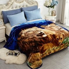 a bed covered in a blue comforter with two lions on it