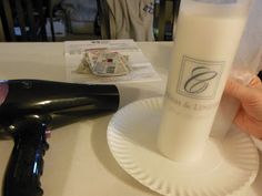 a white paper plate with a black blow dryer on it next to a bottle of deodorant