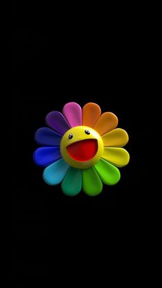 a colorful flower with a smiley face on it's back side, against a black background