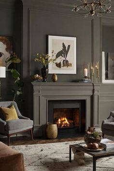 a living room filled with furniture and a fire place under a chandelier in front of a fireplace