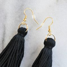 This is it: can't-go-wrong classic black tassel danglers in lighter-than-air cotton. I think you just met your new favorite earrings. LONG is 3.25 inches and MINI is 2.5 inches from the top of the ear wire (each piece is handmade so lengths are approximate) hand-tied cotton tassel in black gold-plated stainless steel ear wire hooks lead-free and nickel-free plastic earring back for security packaged on a hand-stamped kraft earring card in a clear resealing bag Black Fringe Tassel Drop Earrings, Black Fringe Drop Earrings, Black Fringe Dangle Earrings, Black Tassel Drop Earrings, Minimalist Tassel Drop Earrings, Black Tassel Earrings With Ear Wire As A Gift, Black Drop Tassel Earrings As Gift, Decades Of Fashion, Plastic Earrings