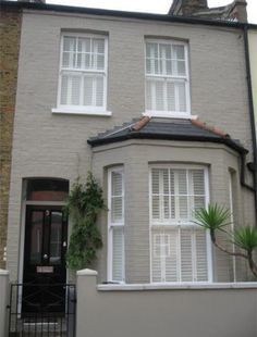 a grey house with white windows and shutters