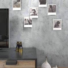 a tv sitting on top of a wooden dresser in front of a wall with pictures