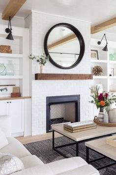 a living room filled with furniture and a fire place in front of a white fireplace