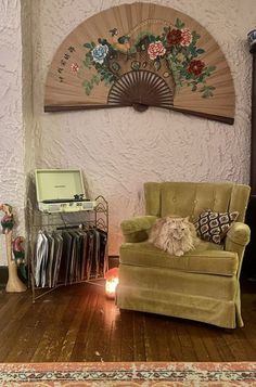 a living room filled with furniture and a fan on the wall above it's fireplace