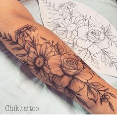 a woman's arm with flowers and leaves on it