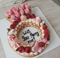 a cake decorated with flowers and hearts on top of a white card that says, viviz you henry me?