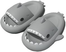 two gray slippers with white teeth and mouth shapes on them, one is shaped like a shark