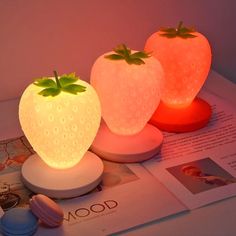 two strawberry shaped lights sitting on top of a table