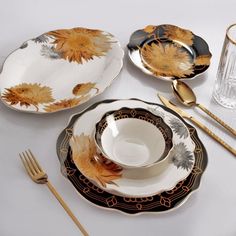 the table is set with gold and black dishes