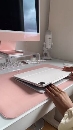 a person sitting at a computer desk with a pink mat on the keyboard and mouse pad