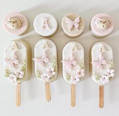 there are six cake pops decorated with teddy bears and flowers on them, along with the letters a, b, c, d