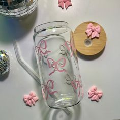 a glass mug with pink bows on it next to other decorations and confetti