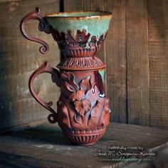 a ceramic vase sitting on top of a wooden table