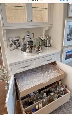 an open cabinet filled with bottles and glasses