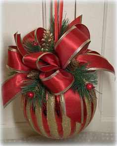 a red and gold christmas ornament with pine cones