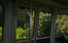 the inside of a passenger train with trees in the backgrouds and windows