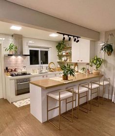 a kitchen with white cabinets and wooden floors