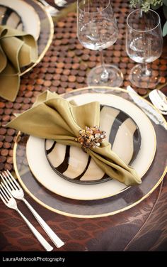 a table set with plates, silverware and napkins