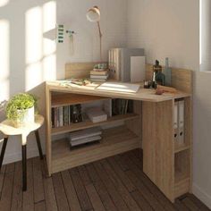 a computer desk with books and magazines on it in a room that has wooden floors